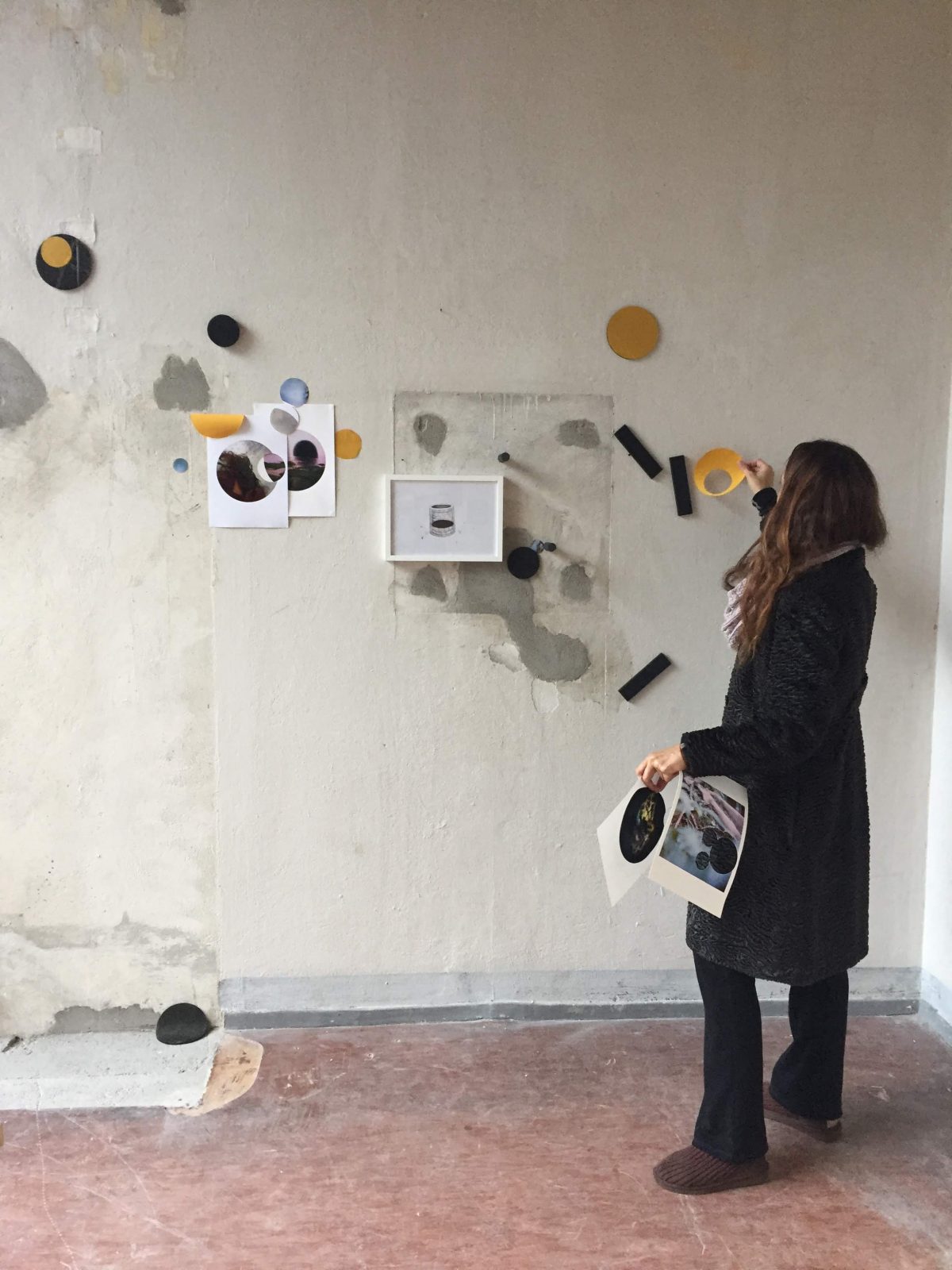 Kirstin Broussard stands in front of her wall collage work.