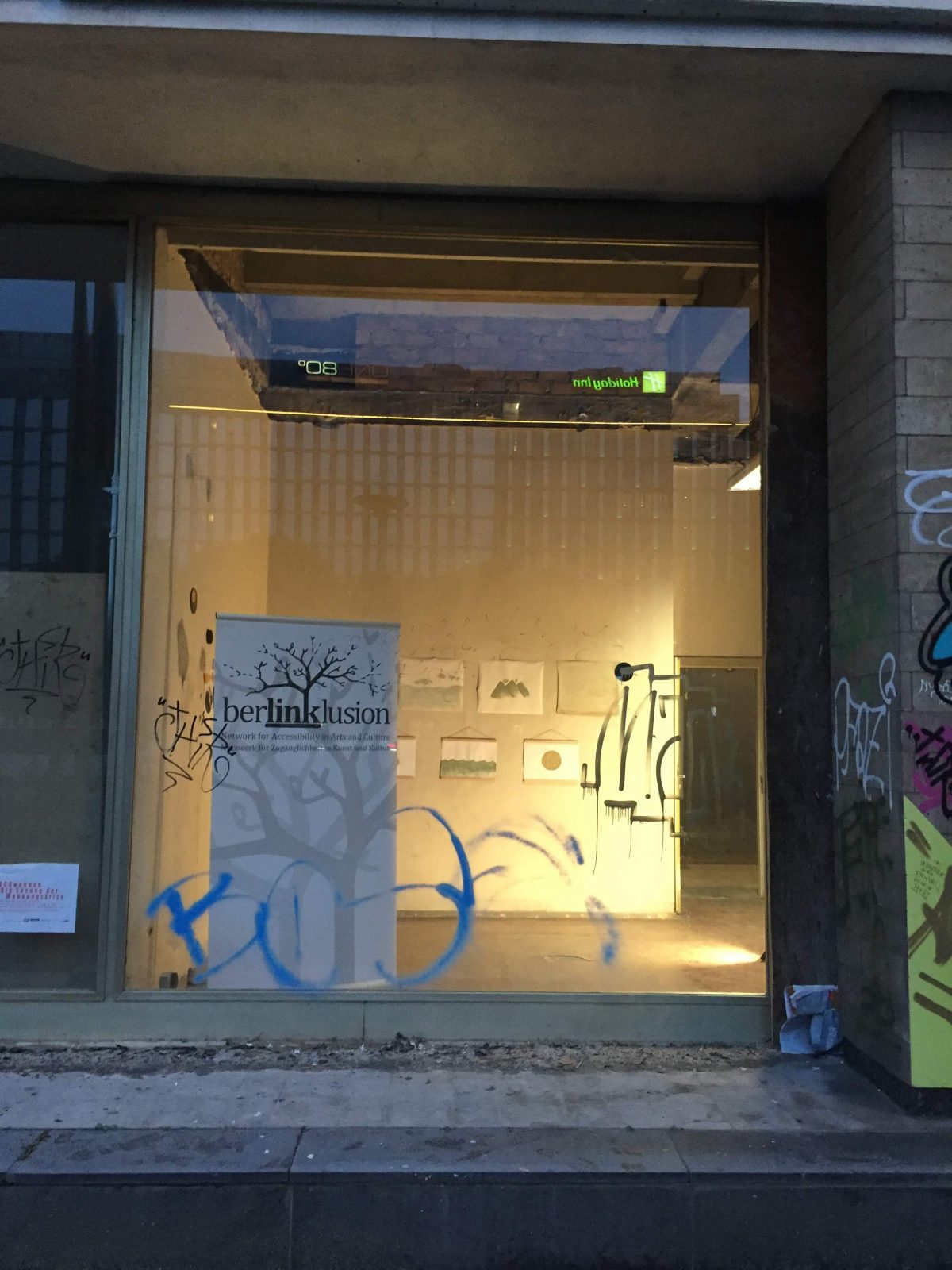 Seen from the outside at dusk, the You Are Not Invited exhibition is seen from outside the Haus der Statistik building.